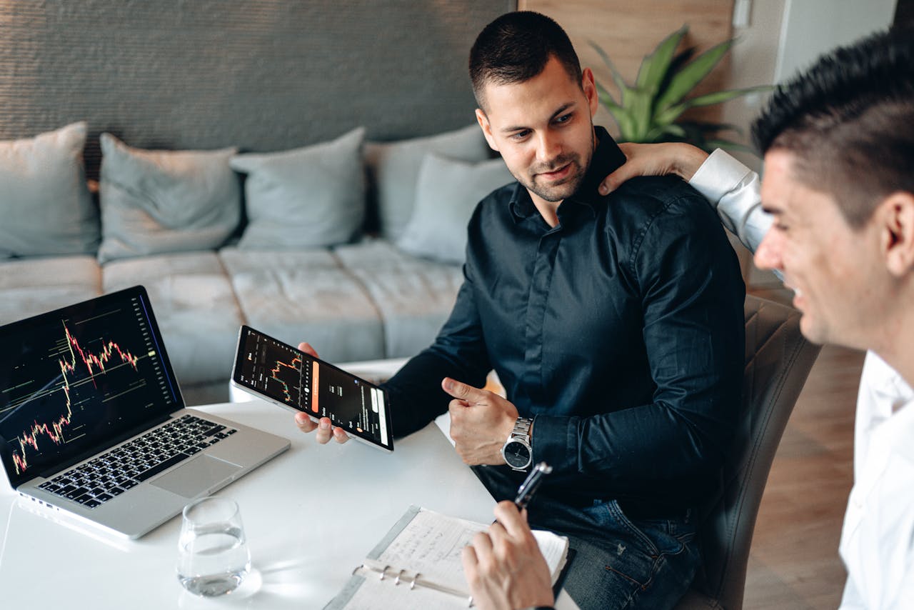 Two professionals engage in a strategy meeting using digital tech for data analysis.